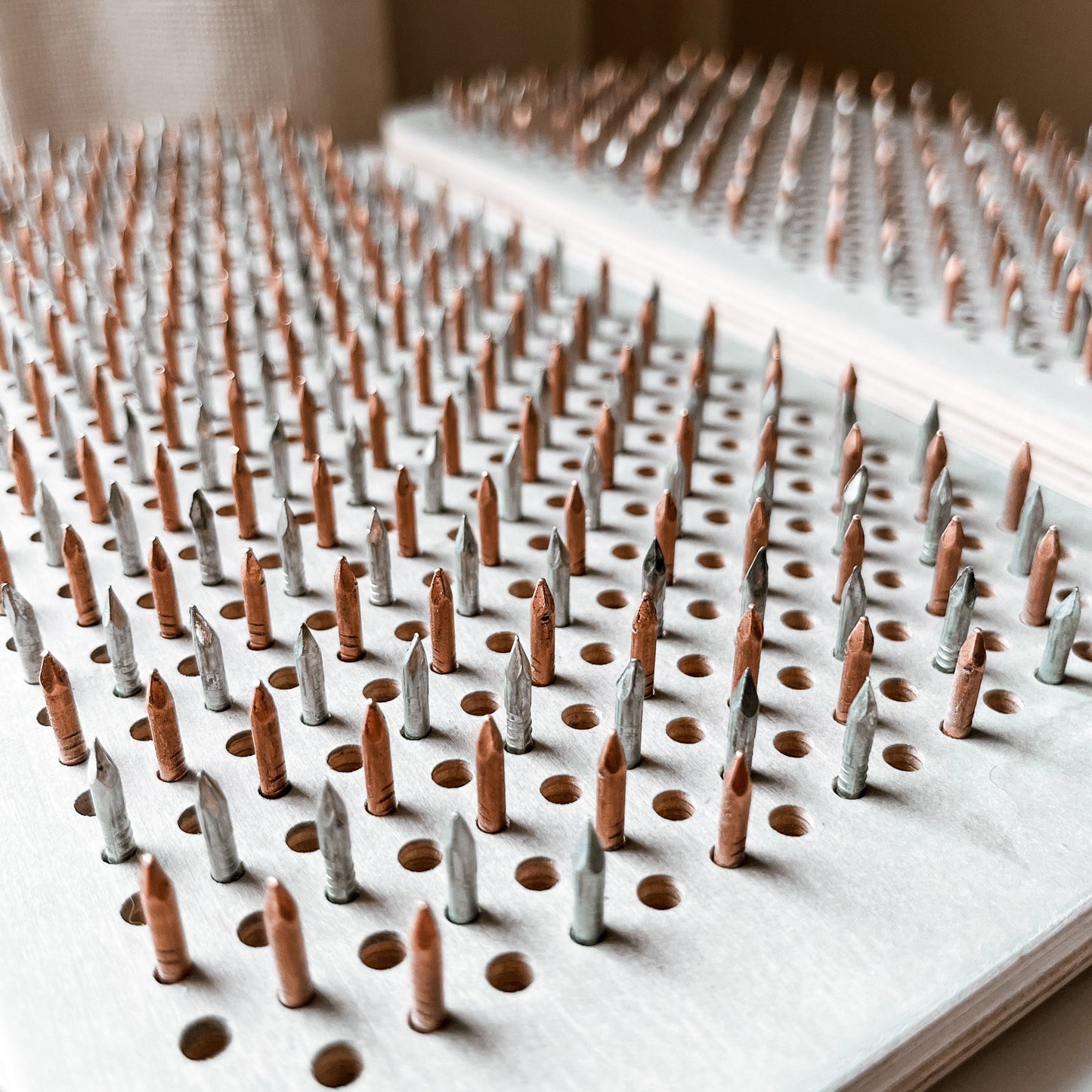 Close-up of the copper and stainless nails on the Yin-Yang Sadhu Board, providing acupressure benefits.